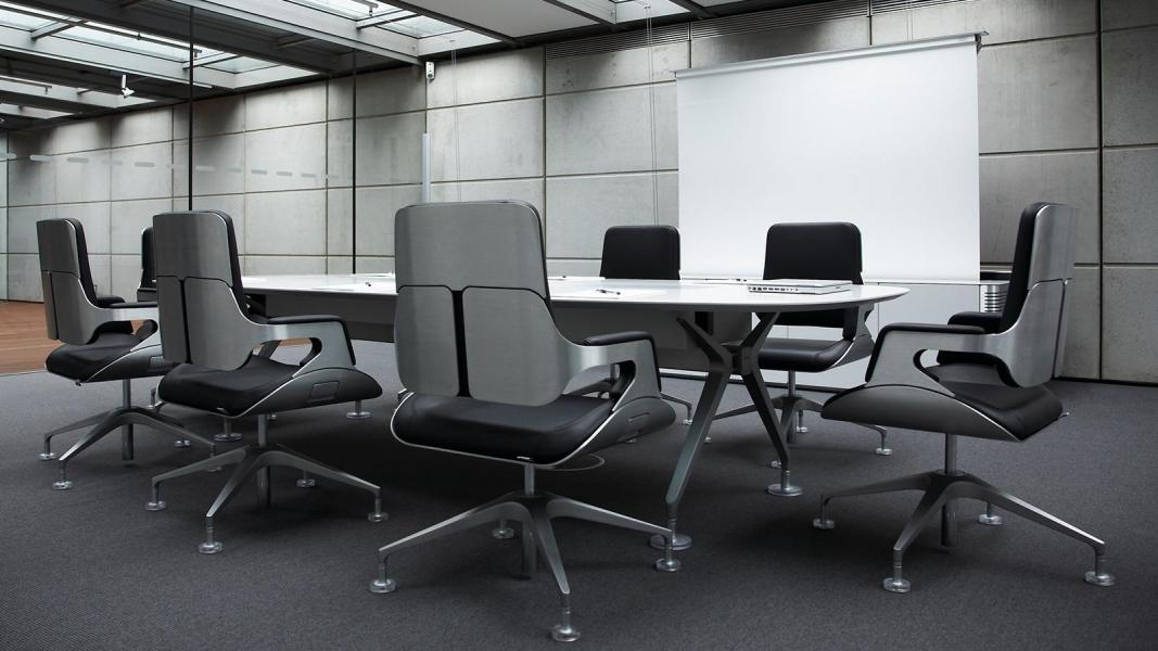 Konferenzraum mit grauen Stühlen und hellem Tisch